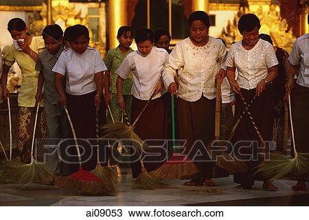 Stock Image - Myanmar (Burma), Yangon, Women volunteers sweeping the floor at Shwedagon Paya.. Fotosearch