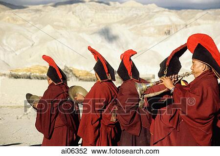 Stock Image - Nepal, Mustang, Buddhist lamas play their instruments in a procession to toss out evil spirits.. Fotosearch