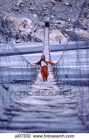 Pakistan, Northern Areas, Hunza Valley, Villager crossing rope bridge. View Large Photo Image Stock Image - Pakistan, Northern Areas, Hunza Valley, Villager crossing rope bridge.. Fotosearch