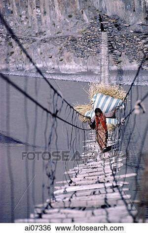 Pakistan, Northern Areas, Hunza Valley, Hussaini Village, Woman carrying wheat crossing rope bridge. View Large Photo Image Stock Photograph - Pakistan, Northern Areas, Hunza Valley, Hussaini Village, Woman carrying wheat crossing rope bridge.. Fotosearch