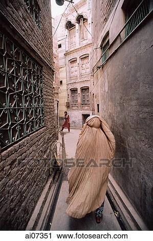 Stock Image - Pakistan, Punjab, Multan, Woman wearing Purdah walking in alley.. Fotosearch