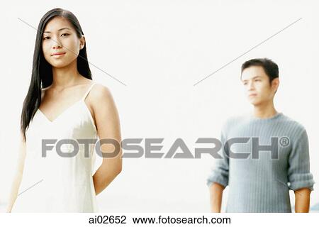 Stock Image - Portrait of woman with man in background. Fotosearch