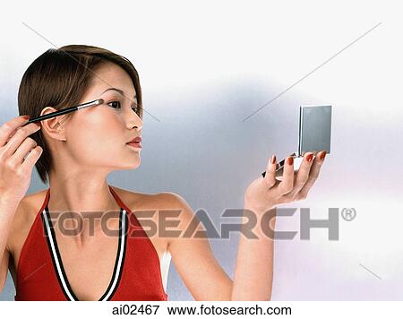Profile of woman applying mascara, white background View Large Photo Image Stock Photo - Profile of woman applying mascara, white background. Fotosearch