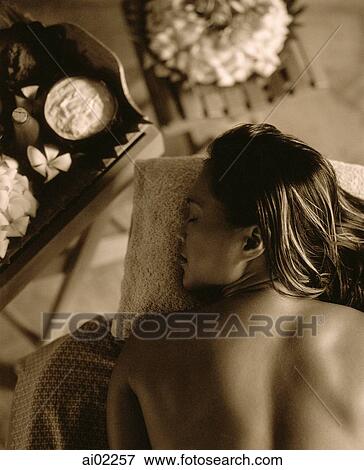 Profile of woman lying down with flowers on table next to her View Large Photo Image Stock Photo - Profile of woman lying down with flowers on table next to her. Fotosearch