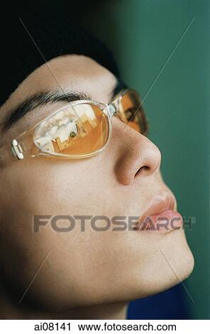 Stock Image - Profile of young man wearing sunglasses and cap.. Fotosearch