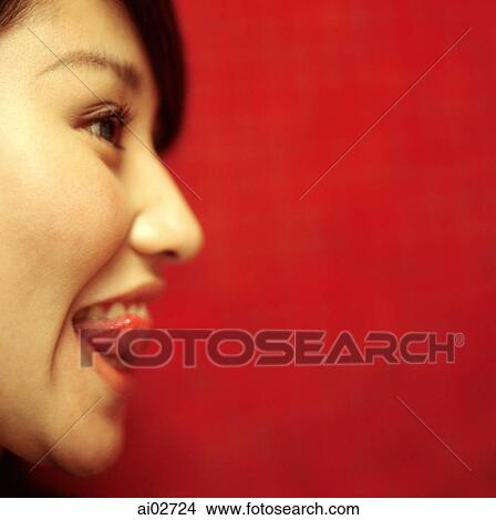 Profile of young woman sticking out tongue, orange/red background. View Large Photo Image Picture - Profile of young woman sticking out tongue, orange/red background.. Fotosearch