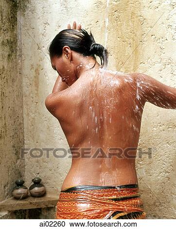 Stock Image - Rear view of woman in outdoor shower. Fotosearch