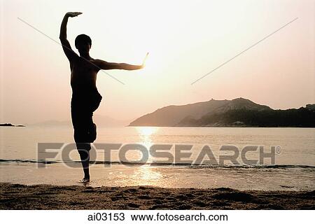 Stock Image - Silhouette of man doing Kung Fu moves at beach. Fotosearch
