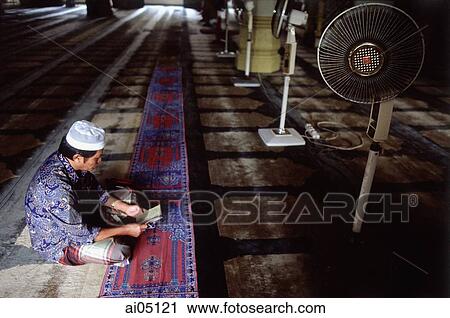 Singapore, A Muslim man reading in the quiet of a Mosque along Arab Street. View Large Photo Image Stock Image - Singapore, A Muslim man reading in the quiet of a Mosque along Arab Street.. Fotosearch