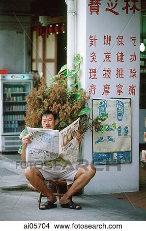 Singapore, Chinatown, Man sitting on stool reading local Chinese newspaper. View Large Photo Image Picture - Singapore, Chinatown, Man sitting on stool reading local Chinese newspaper.. Fotosearch