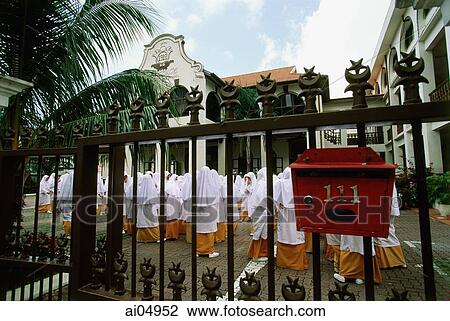 Stock Image - Singapore, students assemble inside gates of the Madrasah Alsagoff Al-Arabiyah (school).. Fotosearch