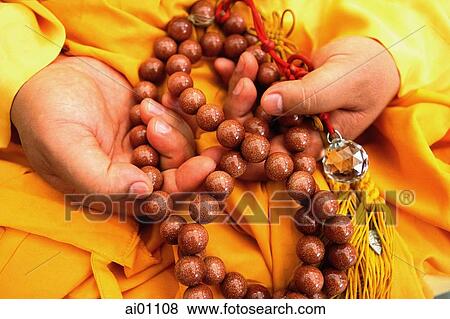 Singapore, Taoist monk wearing yellow robe, holding a rosary of prayer beads View Large Photo Image Stock Photo - Singapore, Taoist monk wearing yellow robe, holding a rosary of prayer beads. Fotosearch