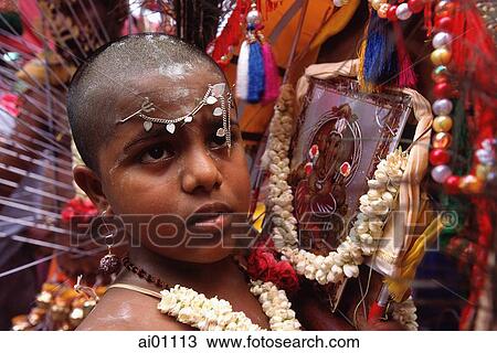 Stock Image - Singapore, Thaipusam Festival, Young Devotee with Hindu icons. Fotosearch