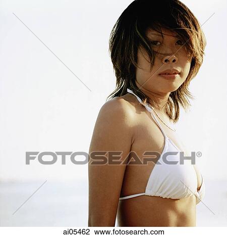 Tanned woman wearing white bikini at beach, portrait View Large Photo Image Stock Image - Tanned woman wearing white bikini at beach, portrait. Fotosearch