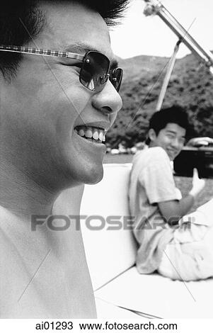 Teen boys in boat with sunglasses, smiling View Large Photo Image Stock Image - Teen boys in boat with sunglasses, smiling. Fotosearch