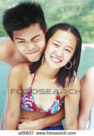 Stock Photo - Teenage couple embracing, in swimwear. Fotosearch
