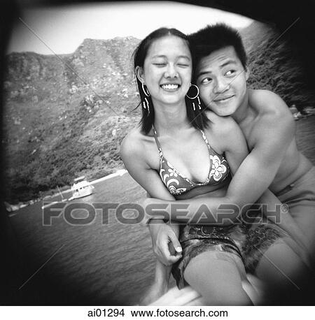 Teenage couple embracing with ocean view behind View Large Photo Image Picture - Teenage couple embracing with ocean view behind. Fotosearch