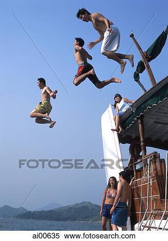 Teenagers jumping off yacht into water View Large Photo Image Stock Photography - Teenagers jumping off yacht into water. Fotosearch