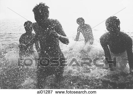 Stock Photo - Teenagers splashing in the ocean, silhouette. Fotosearch