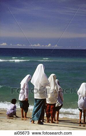 Stock Image - Thailand, Bangkok, Muslim girls in traditional dress by the beach. Fotosearch