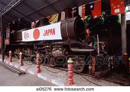 Stock Photograph - Thailand, Kanchanaburi, River Kwai, An old Japanese steam engine sits on display at one of the many museums by the bridge.. Fotosearch