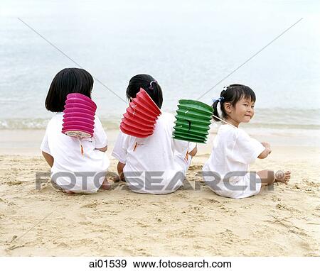 Three children sitting on the beach holding chinese lanterns, rear view View Large Photo Image Stock Photo - Three children sitting on the beach holding chinese lanterns, rear view. Fotosearch