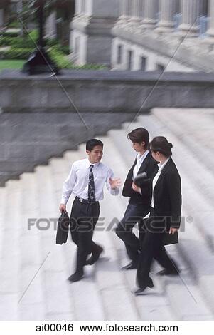 Three executives walking down a flight of steps View Large Photo Image Stock Photograph - Three executives walking down a flight of steps. Fotosearch
