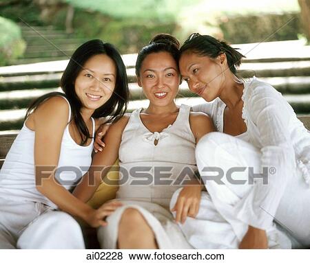 Three women wearing white, sitting together View Large Photo Image Stock Photo - Three women wearing white, sitting together. Fotosearch