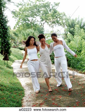 Three women wearing white strolling down path View Large Photo Image Stock Image - Three women wearing white strolling down path. Fotosearch