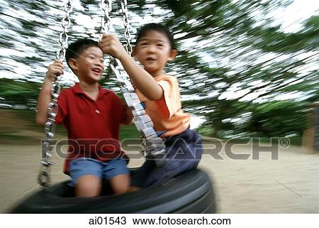 Two boys playing on a swing, (motion blur) View Large Photo Image Stock Image - Two boys playing on a swing, (motion blur). Fotosearch
