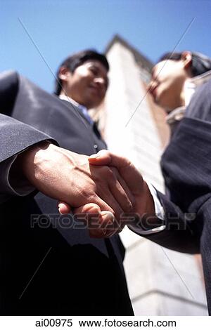 Two executives shaking hands, low angle view View Large Photo Image Stock Photography - Two executives shaking hands, low angle view. Fotosearch