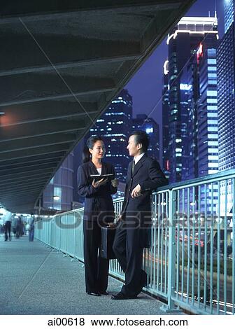 Two executives talking at night, skyline behind View Large Photo Image Stock Photo - Two executives talking at night, skyline behind. Fotosearch