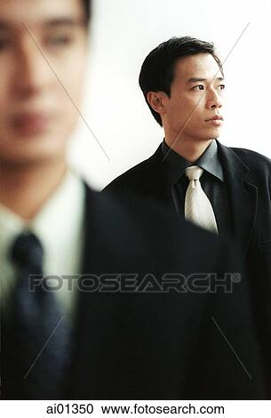 Two male executives, one out of focus in foreground. View Large Photo Image Stock Image - Two male executives, one out of focus in foreground.. Fotosearch