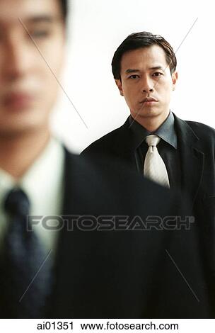Two male executives, one out of focus in foreground. View Large Photo Image Stock Image - Two male executives, one out of focus in foreground.. Fotosearch