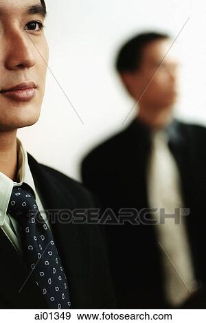 Two male executives, one out of focus in background. View Large Photo Image Stock Photo - Two male executives, one out of focus in background.. Fotosearch