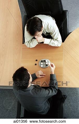 Two male executives playing tic tac toe, overhead view. View Large Photo Image Stock Photograph - Two male executives playing tic tac toe, overhead view.. Fotosearch