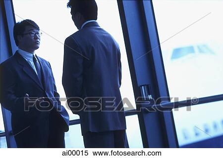 Two male executives talking in airport, silhouette View Large Photo Image Stock Photography - Two male executives talking in airport, silhouette. Fotosearch