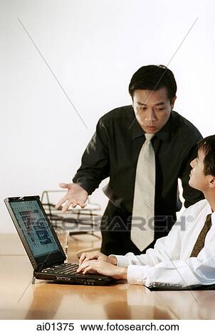 Two male executives talking over laptop computer. View Large Photo Image Stock Photography - Two male executives talking over laptop computer.. Fotosearch
