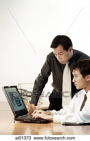 Two male executives working on laptop computer. View Large Photo Image Stock Image - Two male executives working on laptop computer.. Fotosearch