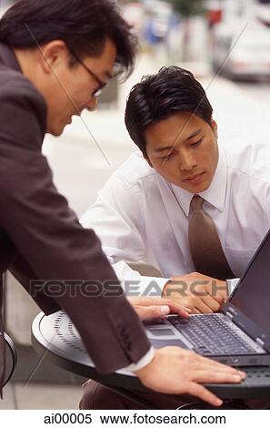 Two male executives working on laptop computer View Large Photo Image Stock Photography - Two male executives working on laptop computer. Fotosearch