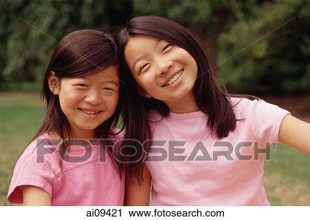 Stock Image - Two sisters smiling, portrait. Fotosearch