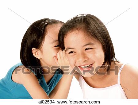 Two young girls whispering to each other, laughing, white background. View Large Photo Image Picture - Two young girls whispering to each other, laughing, white background.. Fotosearch