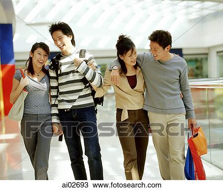 Two young men and two young women walking in shopping mall. View Large Photo Image Stock Image - Two young men and two young women walking in shopping mall.. Fotosearch