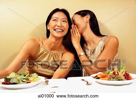 Two young women in restaurant, whispering View Large Photo Image Stock Image - Two young women in restaurant, whispering. Fotosearch
