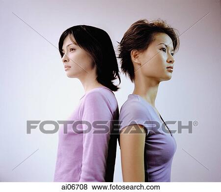 Two young women standing back to back, white background. View Large Photo Image Stock Photo - Two young women standing back to back, white background.. Fotosearch