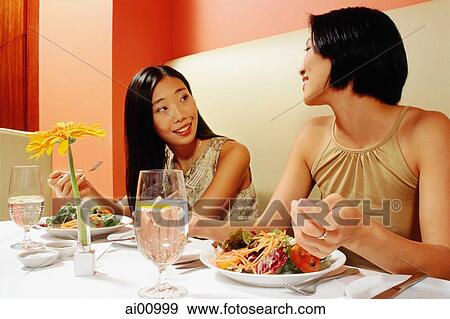 Two young women talking in restaurant View Large Photo Image Stock Photo - Two young women talking in restaurant. Fotosearch