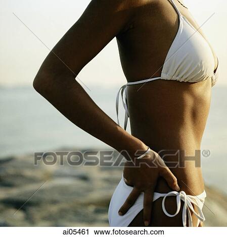 Upper torso of tanned woman wearing white bikini at beach View Large Photo Image Stock Image - Upper torso of tanned woman wearing white bikini at beach. Fotosearch