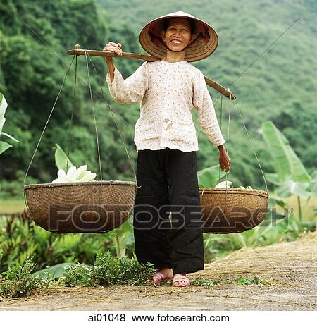 Stock Photo - Vietnam, Halong Bay, Cat Ba Island, old woman carrying baskets of bananas. Fotosearch