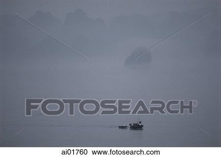 Stock Image - Vietnam, Halong Bay, lone boat in the mist.. Fotosearch