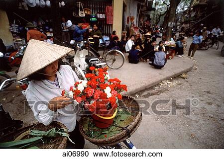 Vietnam, Hanoi, woman holding flowers View Large Photo Image Stock Image - Vietnam, Hanoi, woman holding flowers. Fotosearch